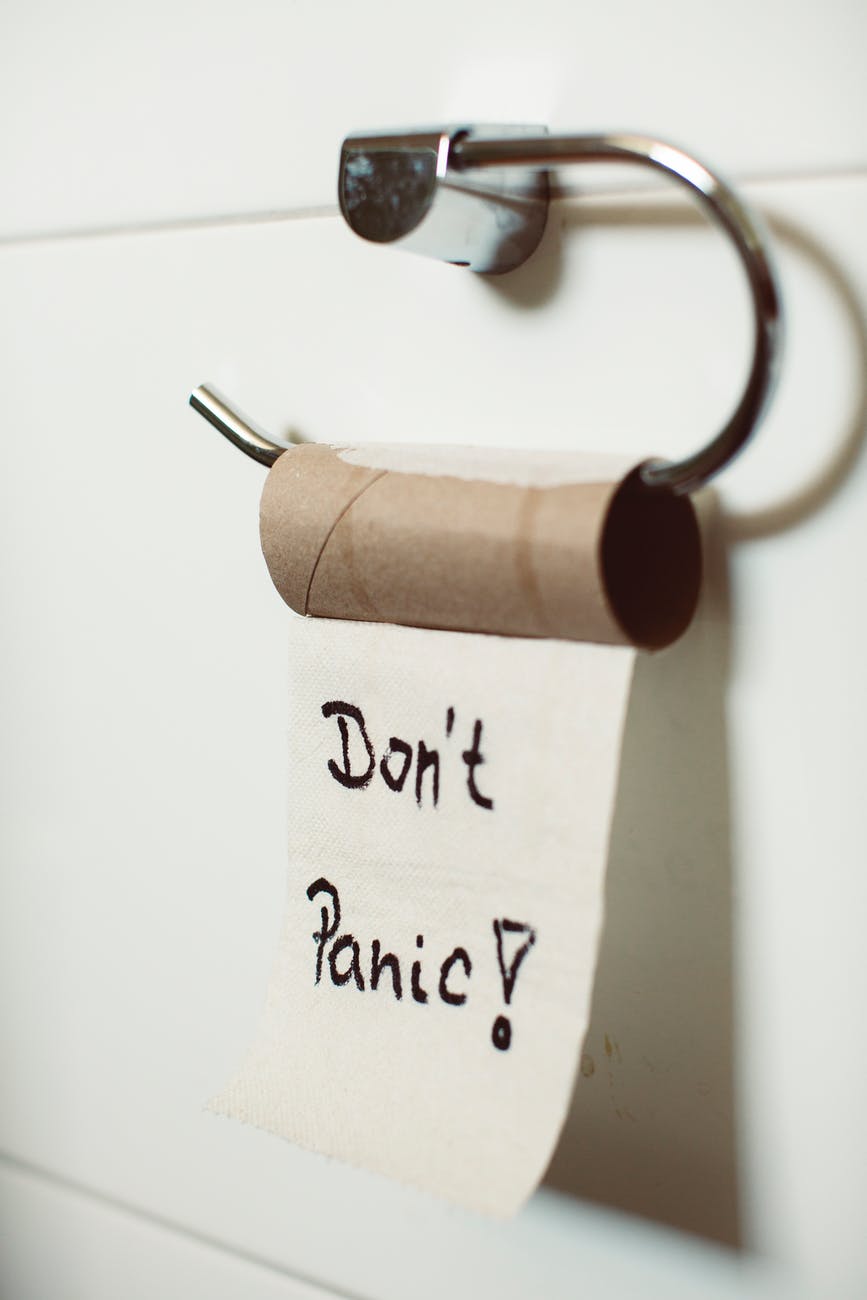empty toilet paper roll with "Don't Panic!" written in blank ink on the final sheet